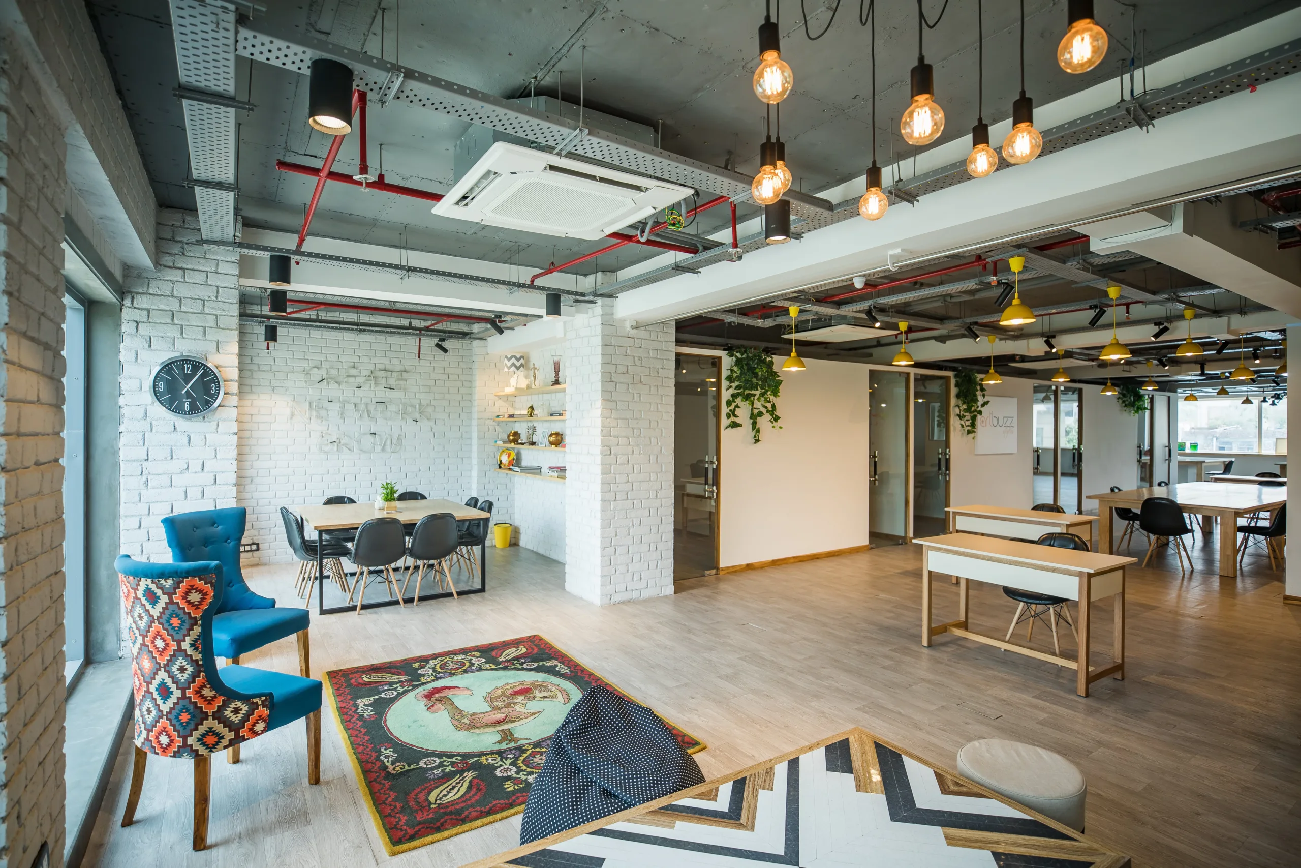 Bright industrial-style commercial space with white brick walls, yellow pendant lights and restored wood floor