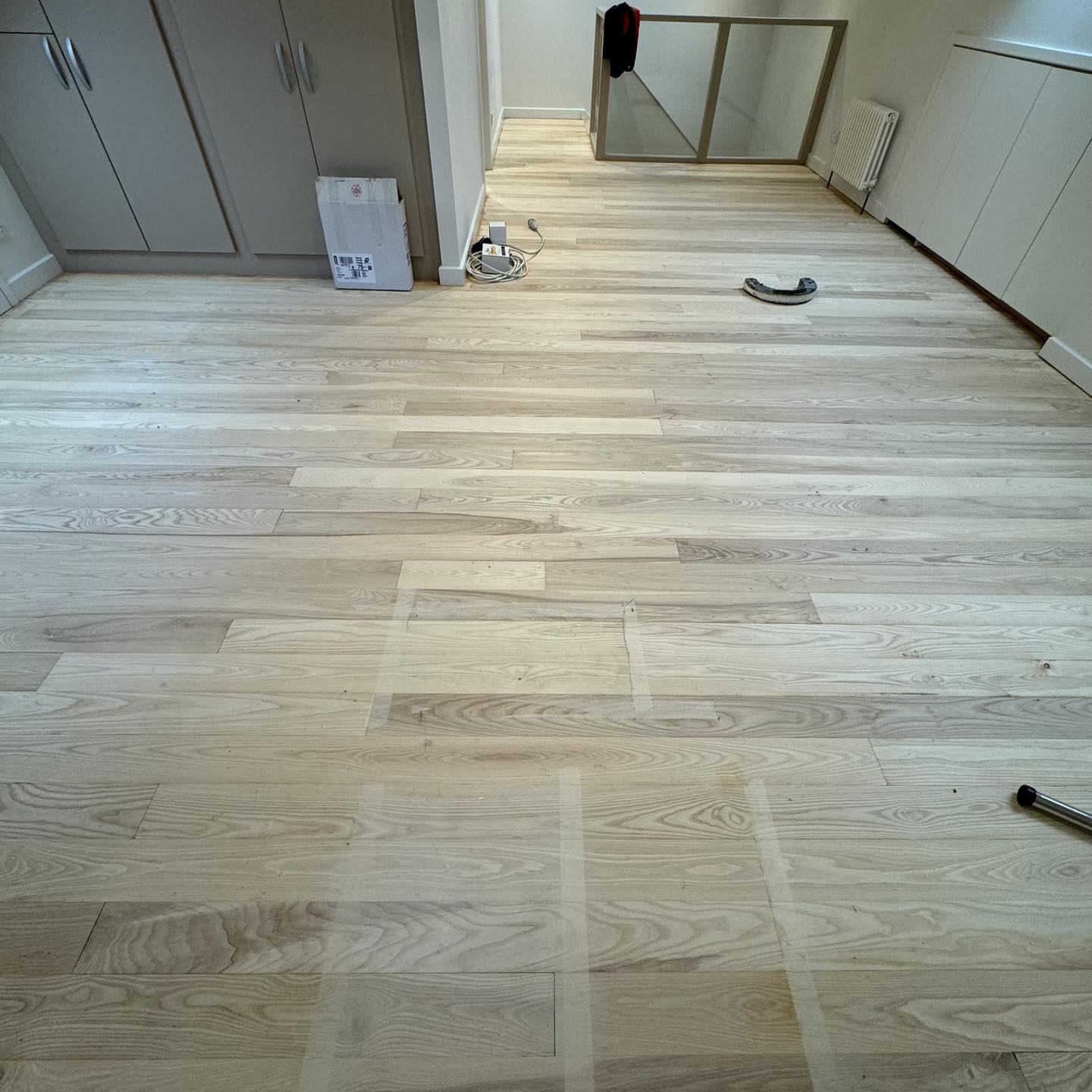 Wood floor in soft natural light with a wooden stool in the foreground