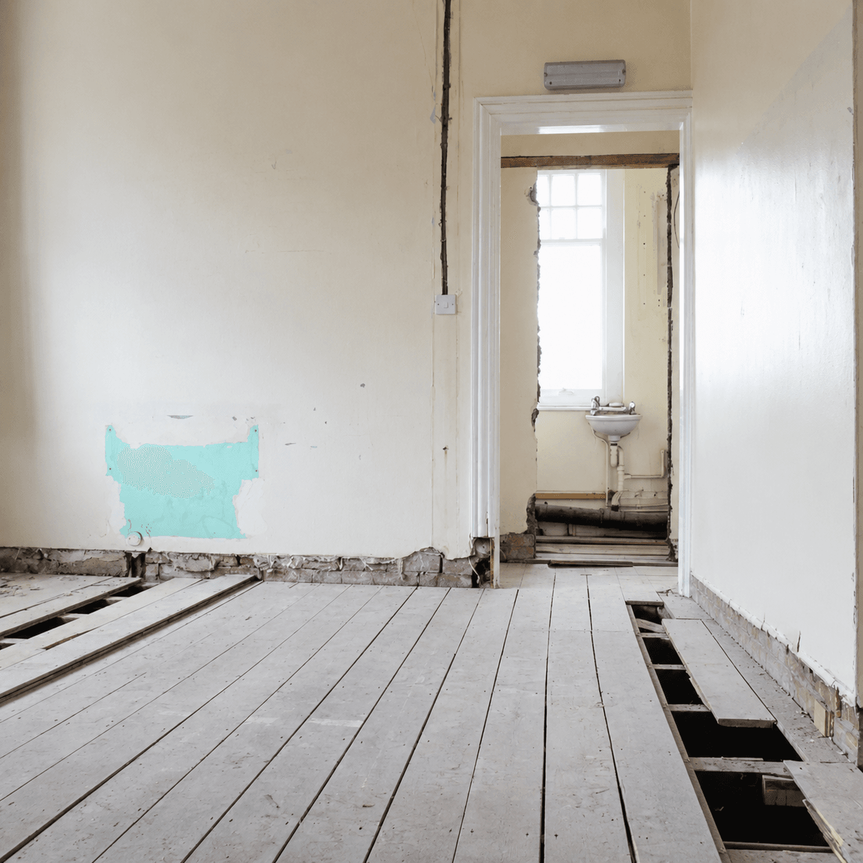 Wooden floor being prepared for sanding with boards lifted and tools laid out
