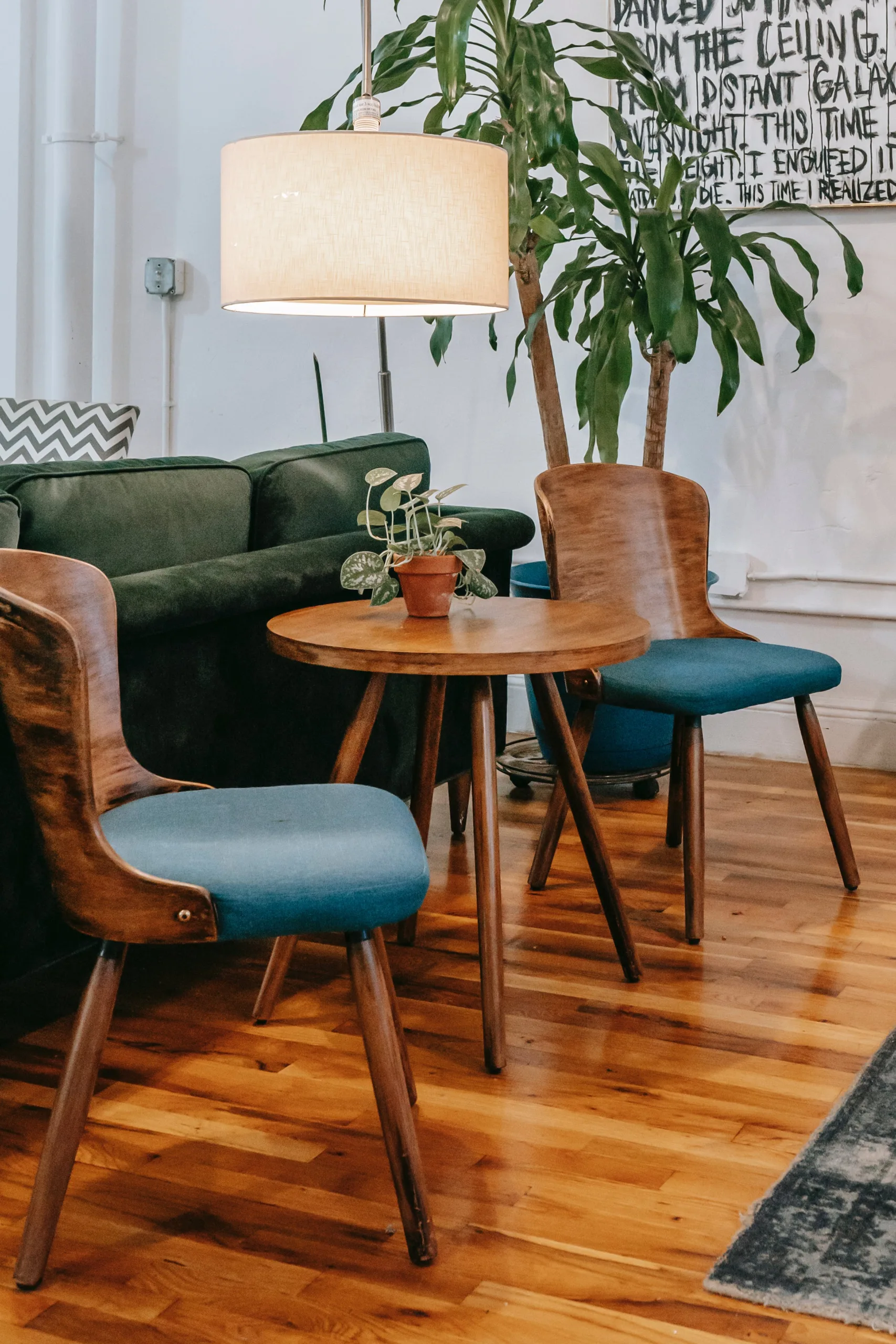 Restored commercial wood floor in a bright workspace with mid-century furniture and houseplant