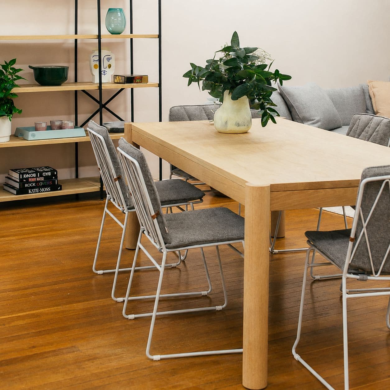 Freshly sanded light wood floor in a bright dining area with table and chairs