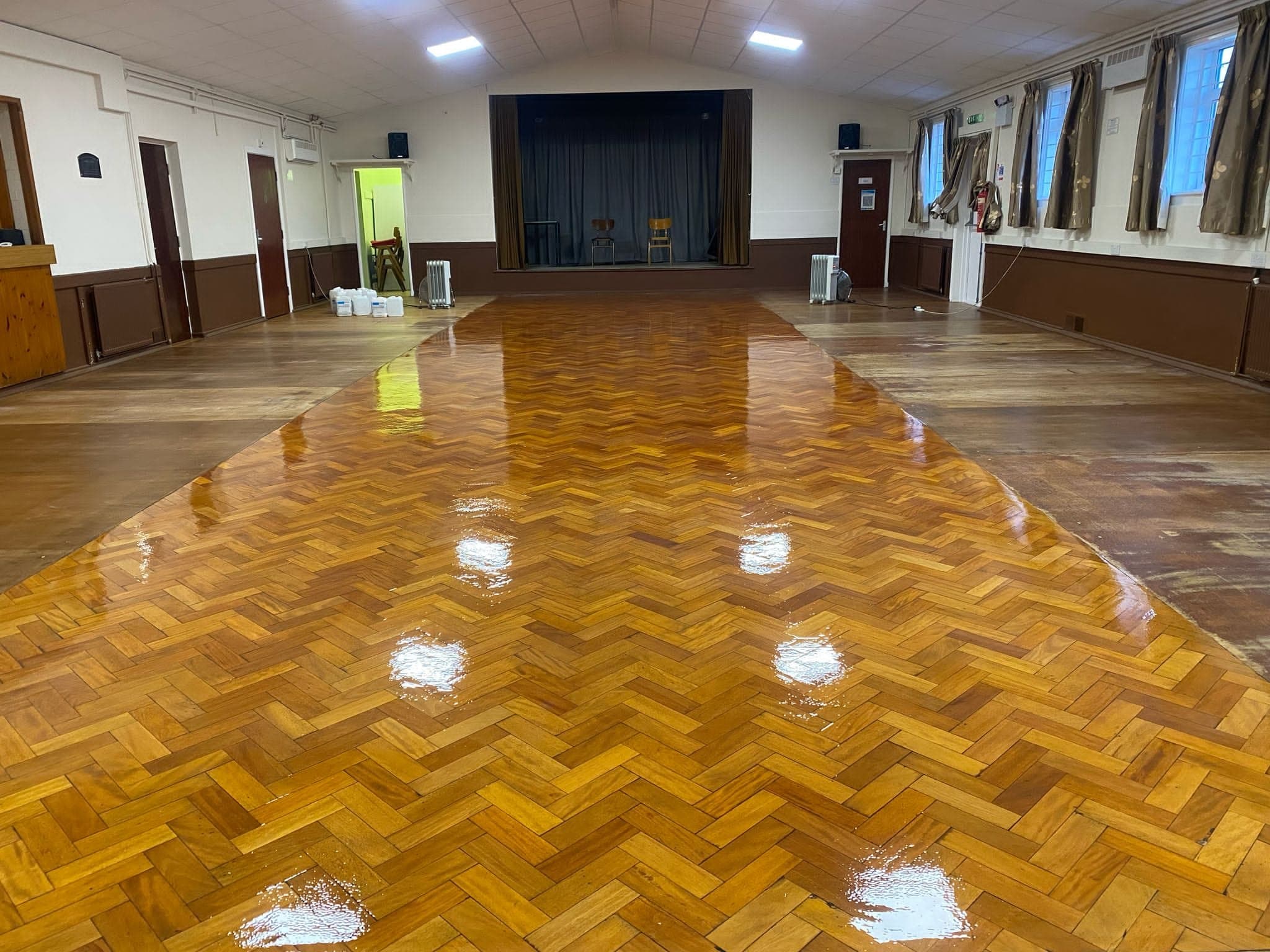 Restored wood floor surface in a school setting after professional repair and refinishing