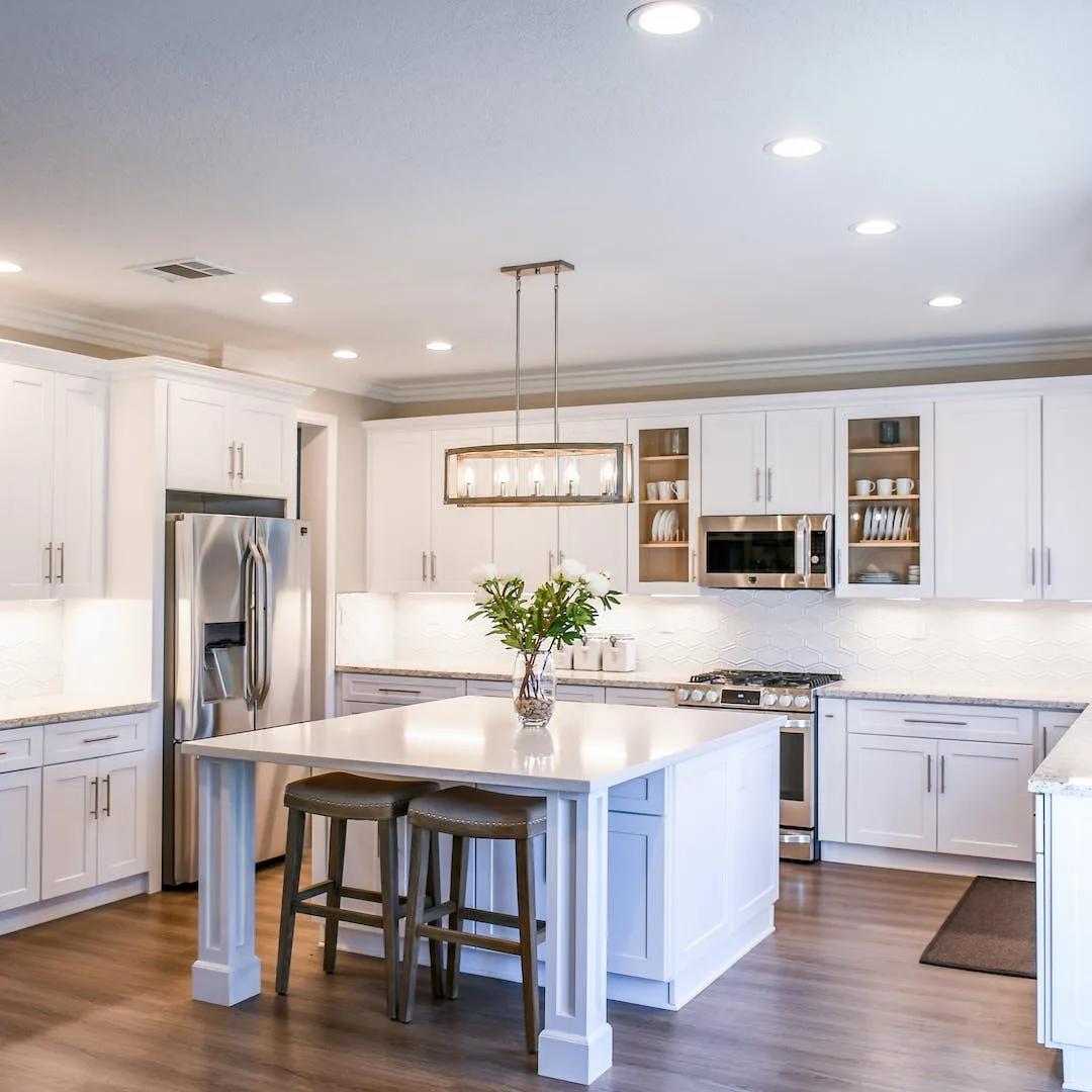 Restored wood floor in a bright kitchen with marble island