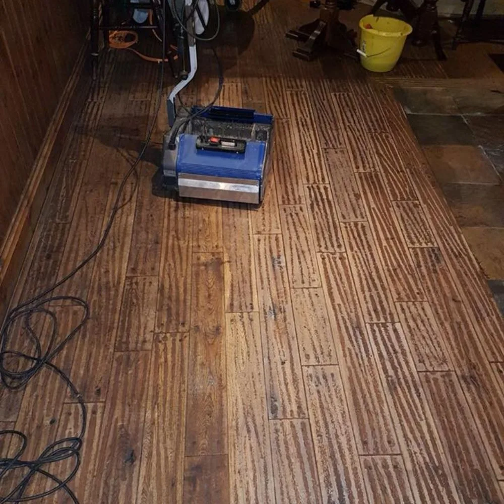 Wooden floor mid-restoration with Floor Angels' industrial cleaning machine in place